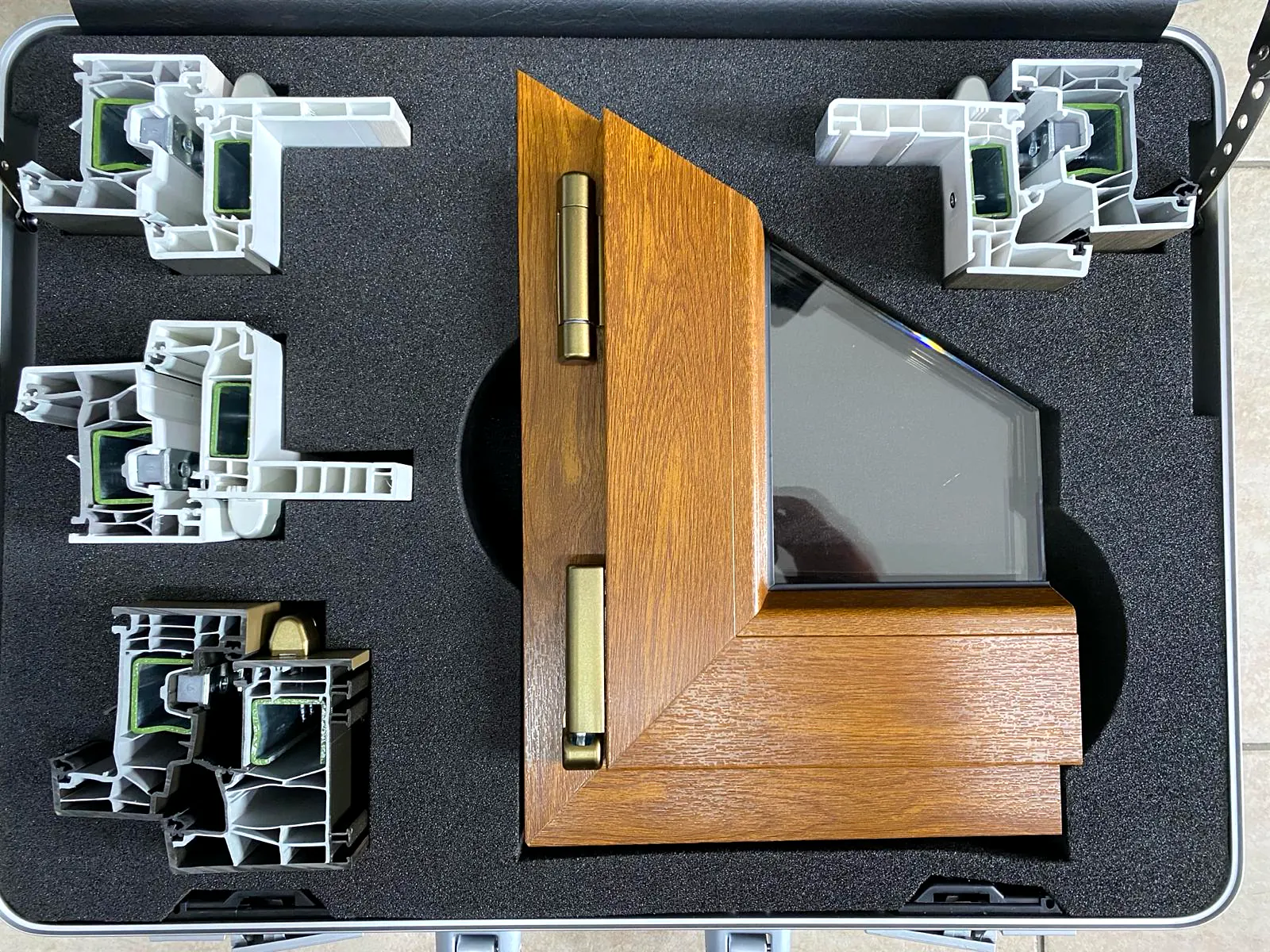 Valigetta con le sezioni reali dei profili e un angolo di serramento effetto legno