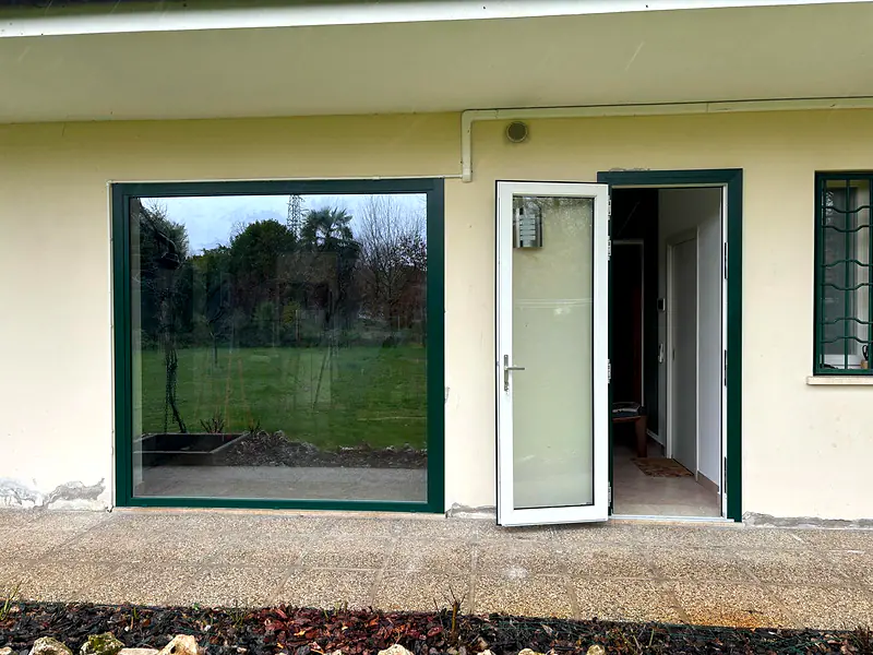 Serramenti verdi consegnati e montati su una casa con giardino